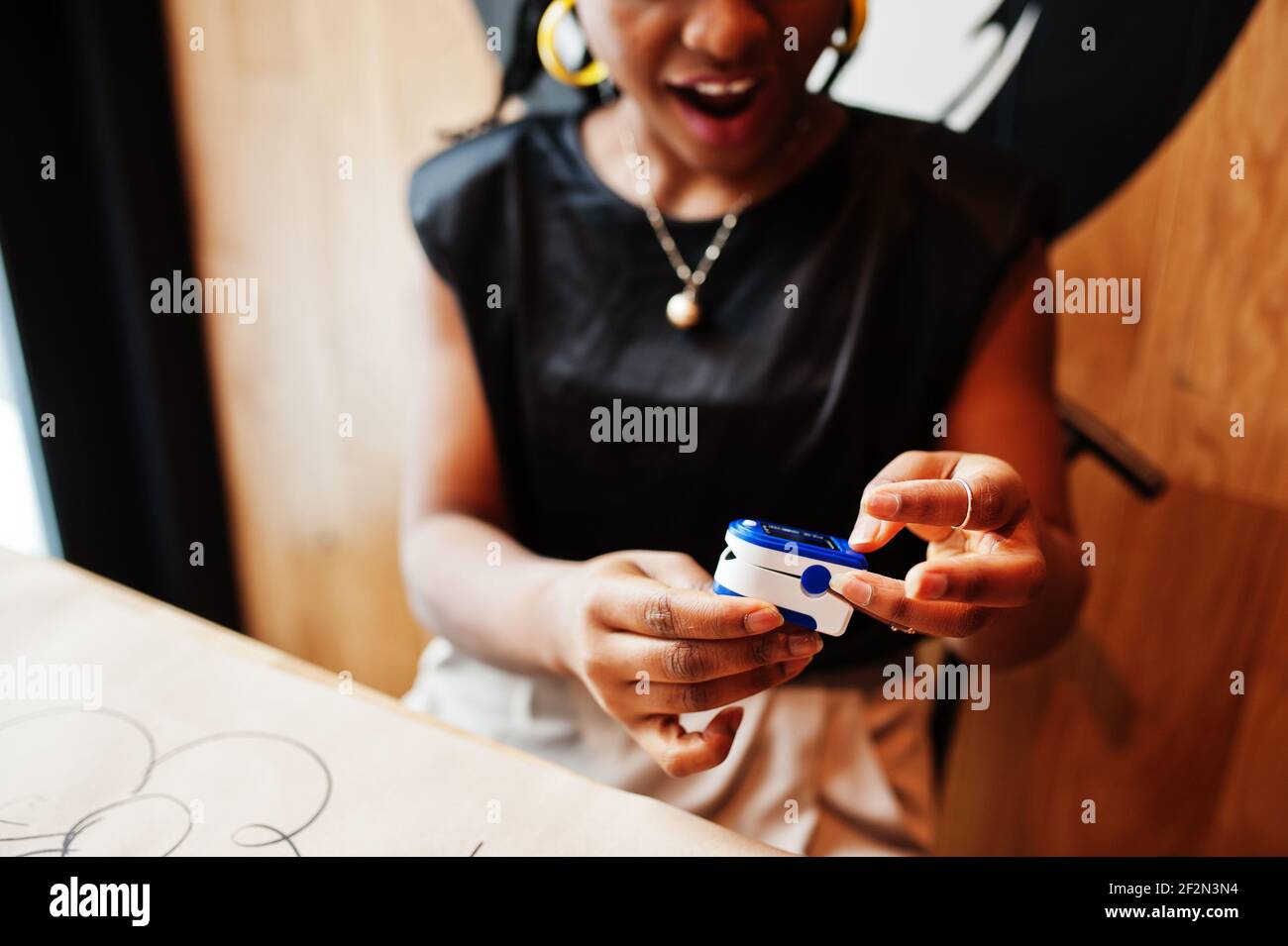 African american women with pulse oximeter on hand measuring oxygen