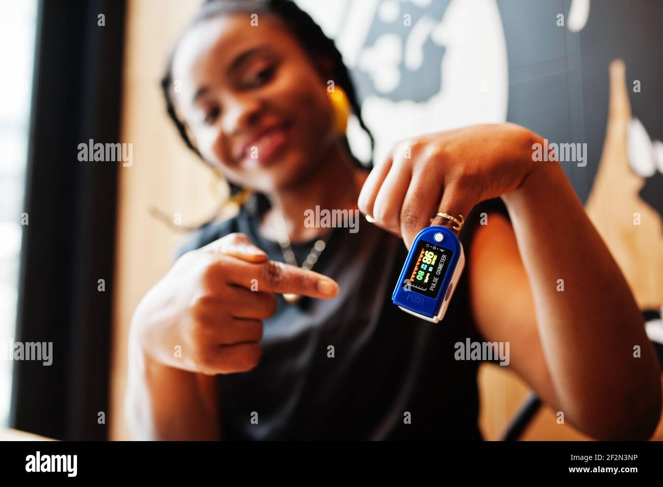 African american women with pulse oximeter on hand measuring oxygen