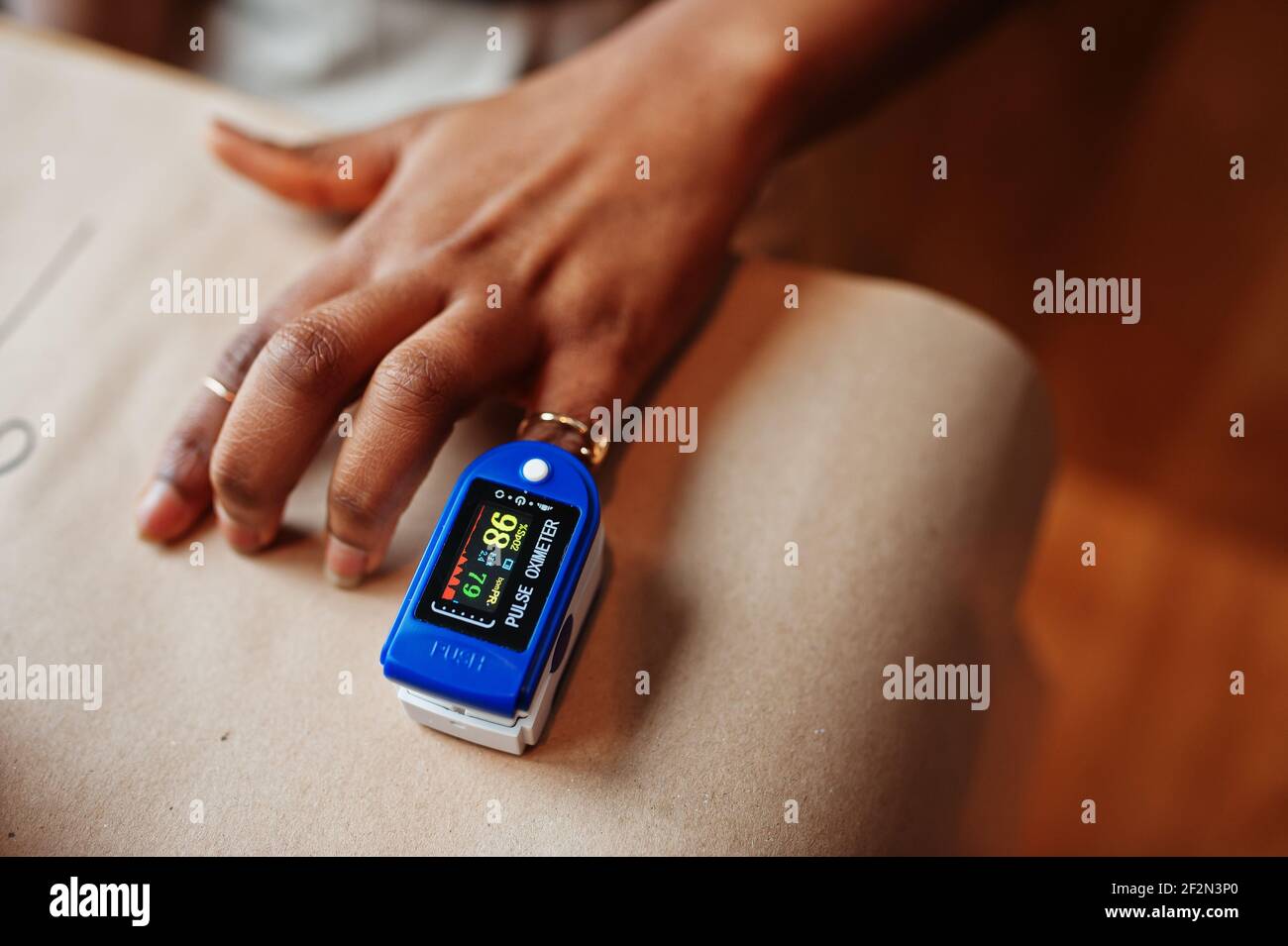African american women with pulse oximeter on hand measuring oxygen