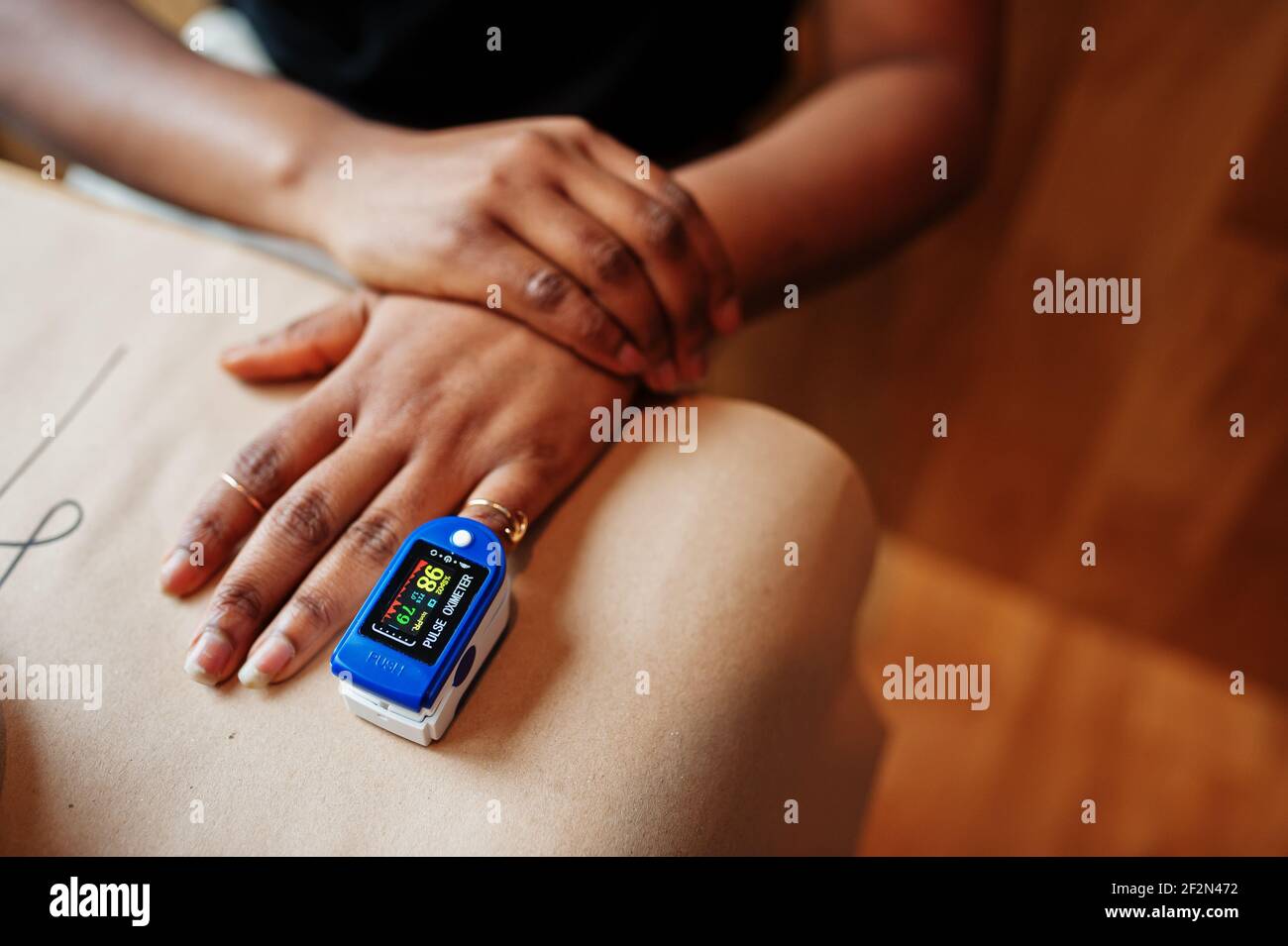 African american women with pulse oximeter on hand measuring oxygen