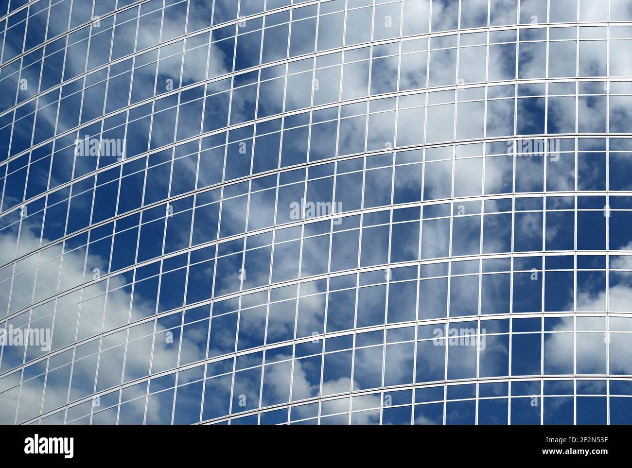 Reflection of a cloudy sky in glass wall of an office building Stock ...