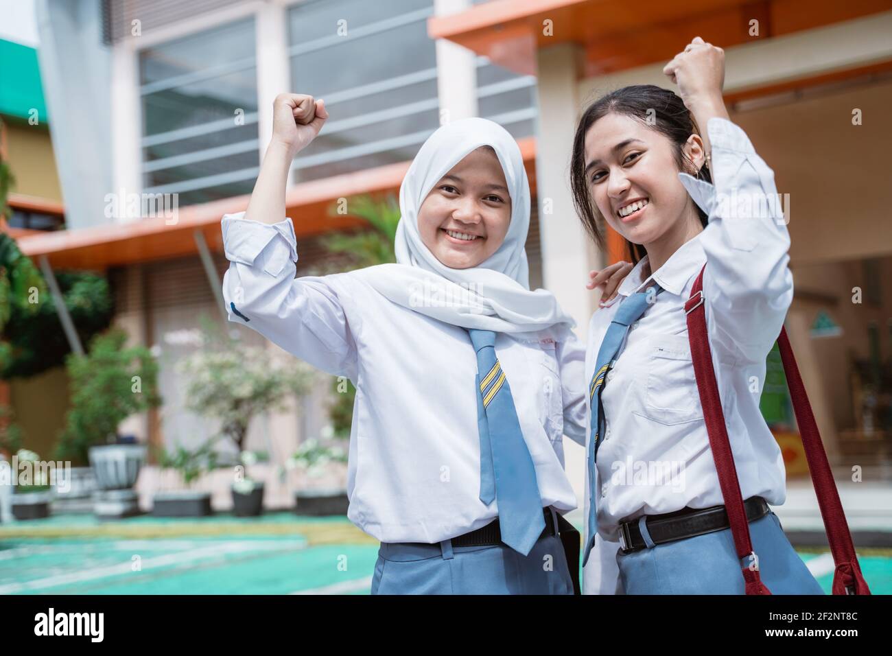 close up of two beautiful student wearing an Indonesian high school uniform  and bag with raise hands Stock Photo - Alamy