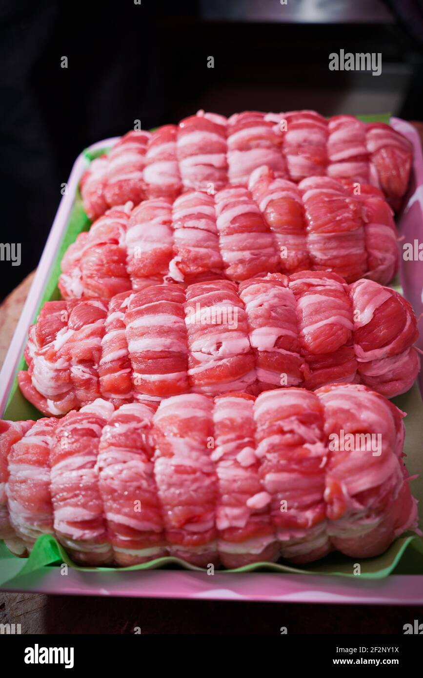 rolls of raw veal meat on a tray in an Italian butcher shop Stock Photo