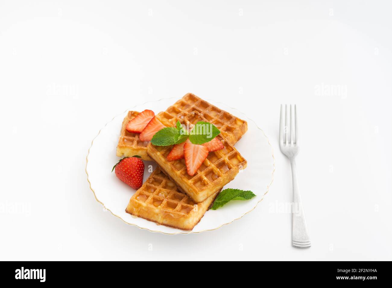 Tasty sweet belgium waffles with strawberry decoration on plate Stock Photo