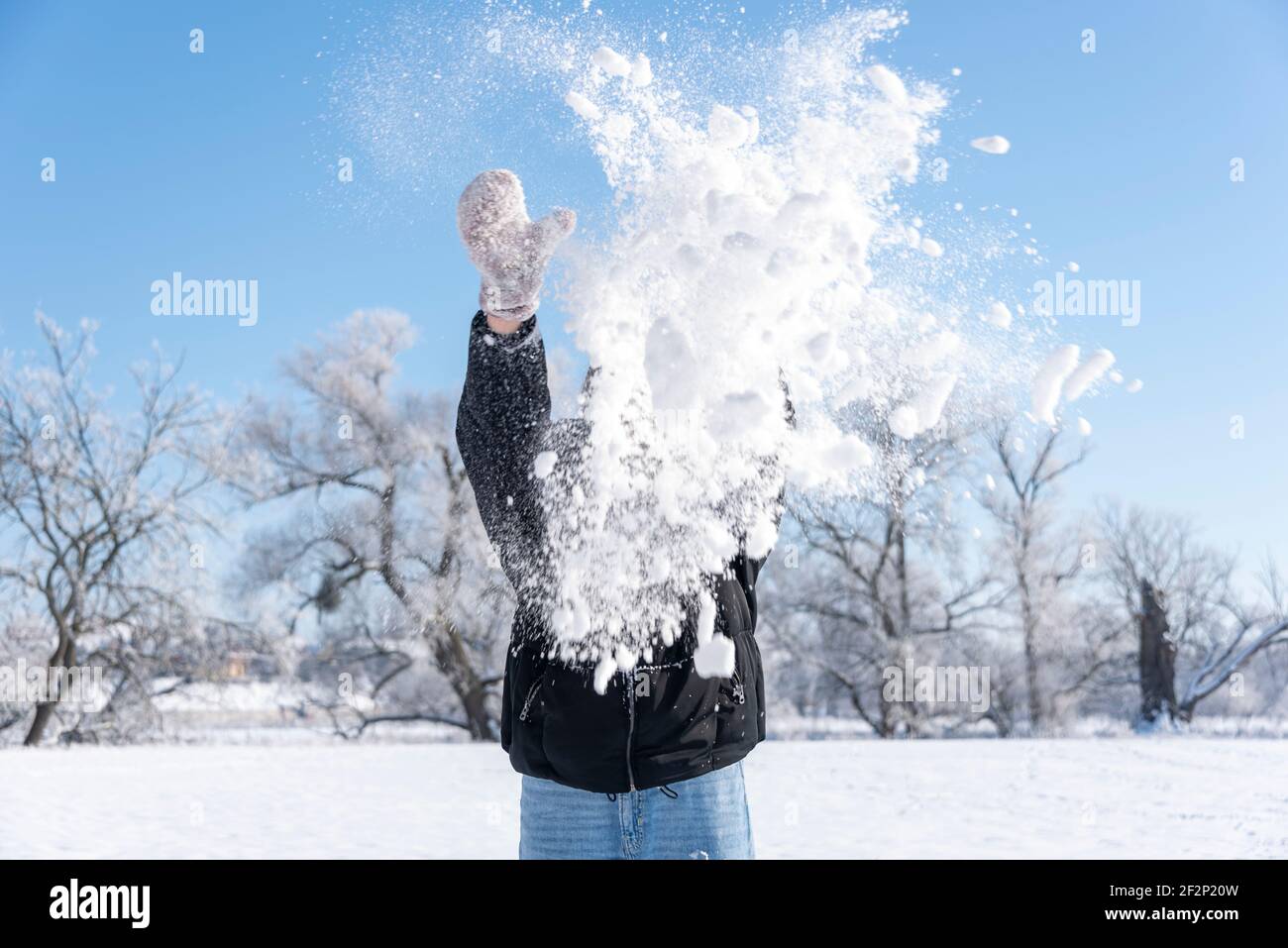 A girl throws snow into the air. Stock Photo