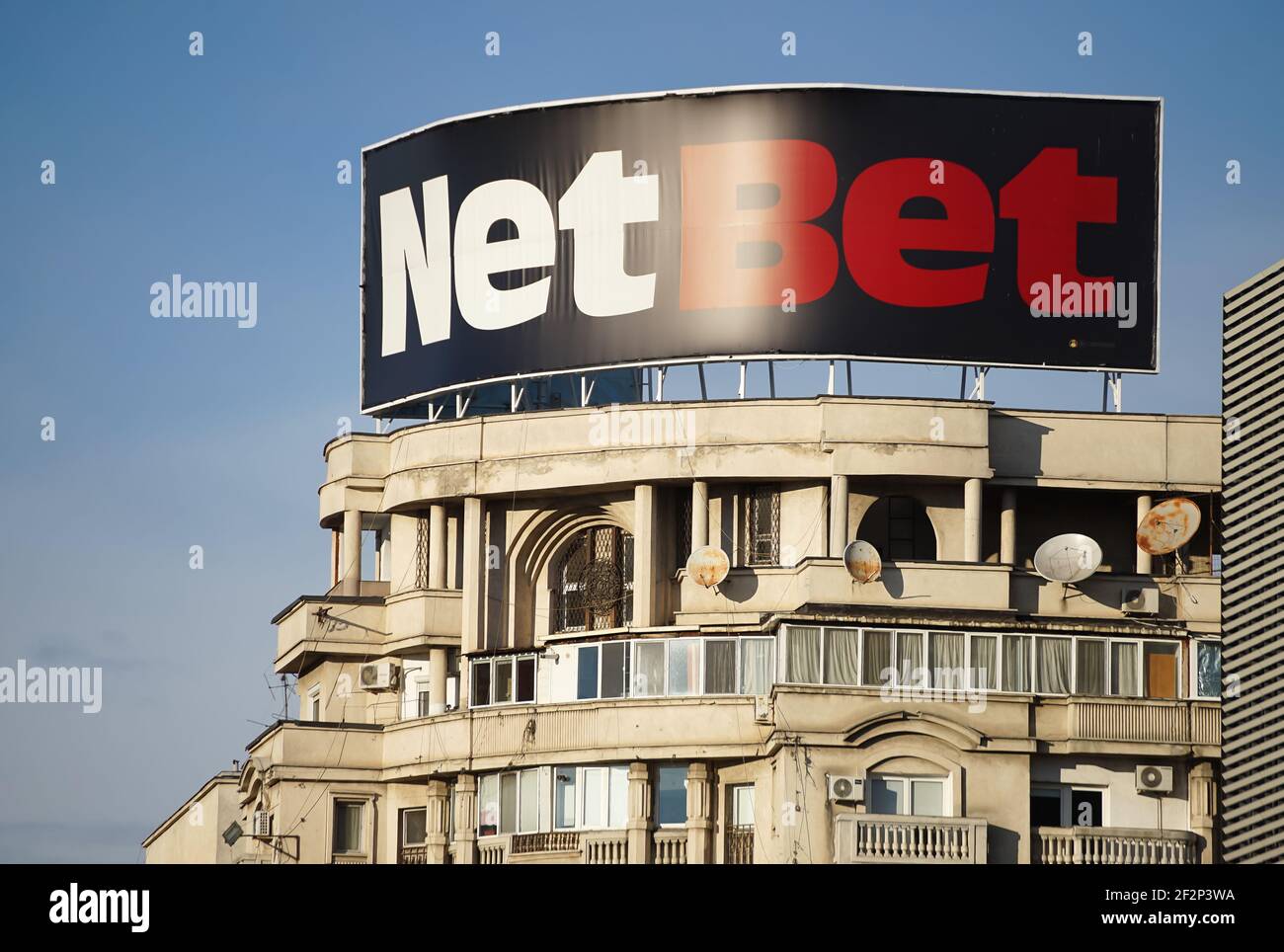 Bucharest, Romania - January 25, 2021: A great NetBet advertisement of the gambling operator NetBet Enterprises Ltd, is seen above a block of flats in Stock Photo