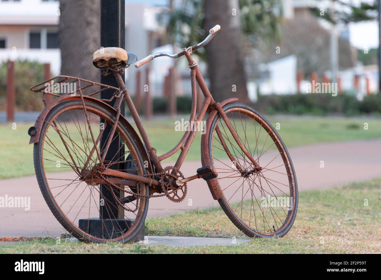 An old rusty bicycle leans up against a lamp post Stock Photo