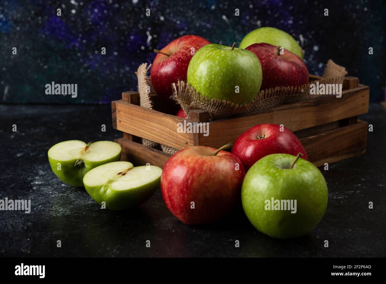 Wooden box of fresh organic apples on black background Stock Photo