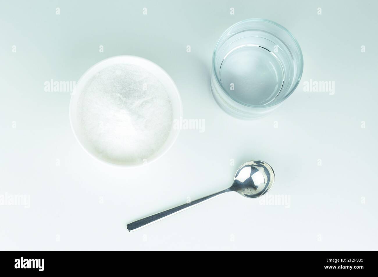 Baking soda, spoon and glass of water. Spoon of baking soda and glass