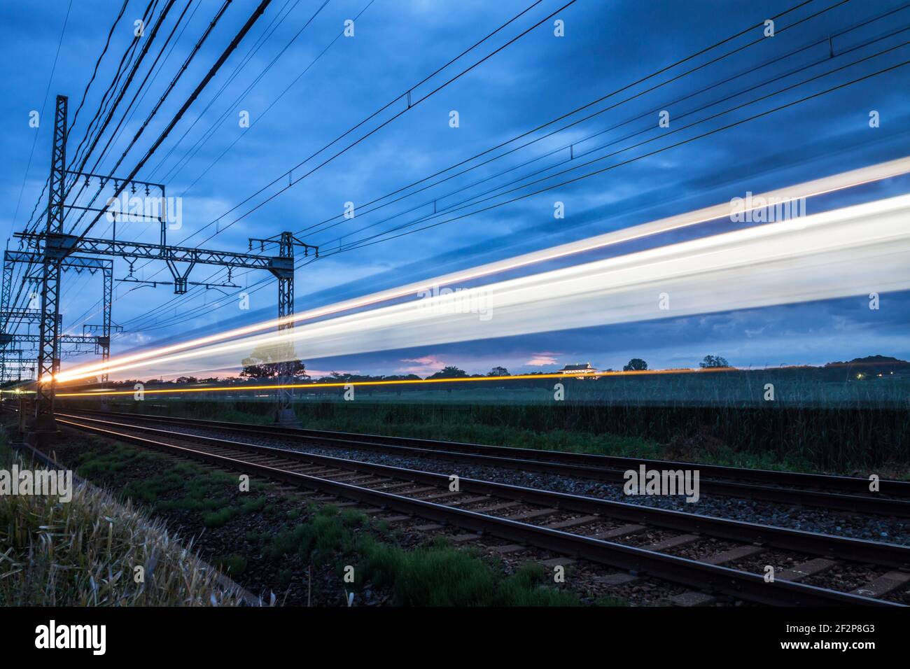 Long exposure of a train rushing by on a railway line at sunset in Nara, Japan Stock Photo