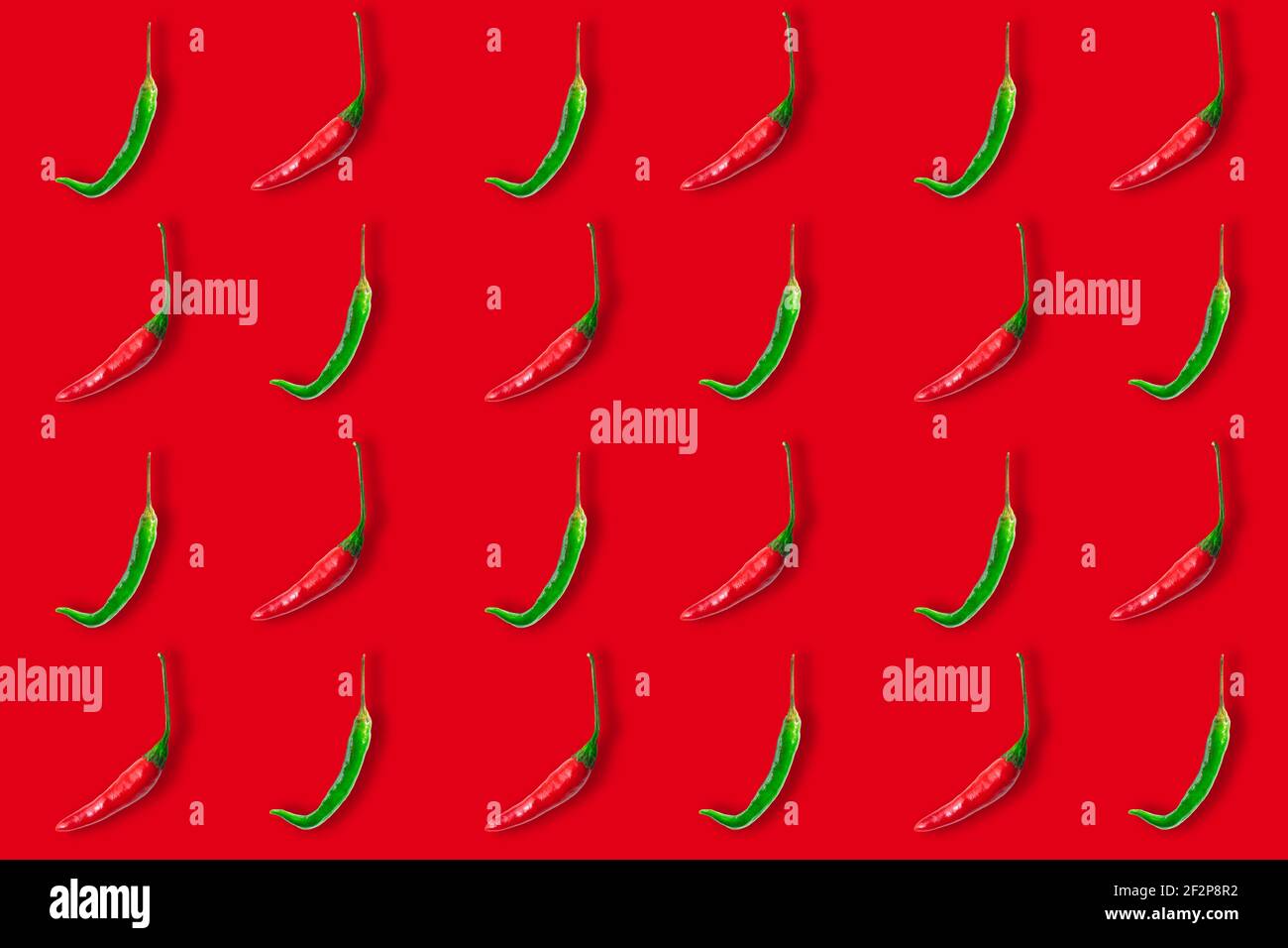 Seamless pattern of red and green hot chili peppers isolated on red background. Top view. Flat lay Stock Photo