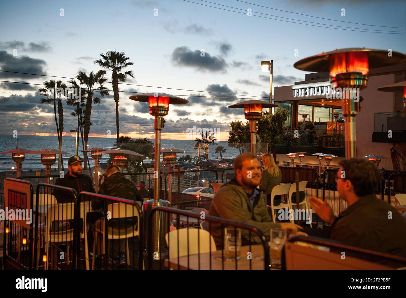People dining outside at Manhattan Beach, CA at sunset Stock Photo