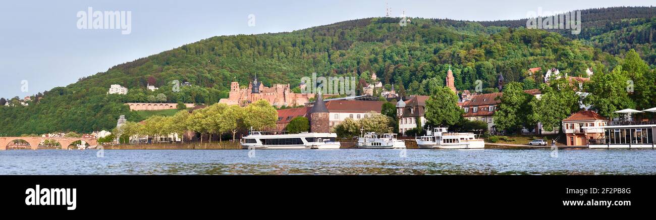 Panoramic view of Heidelberg town in Germany in springtime. Passenger ships moored by the promenade. Panoramic banner image. Stock Photo