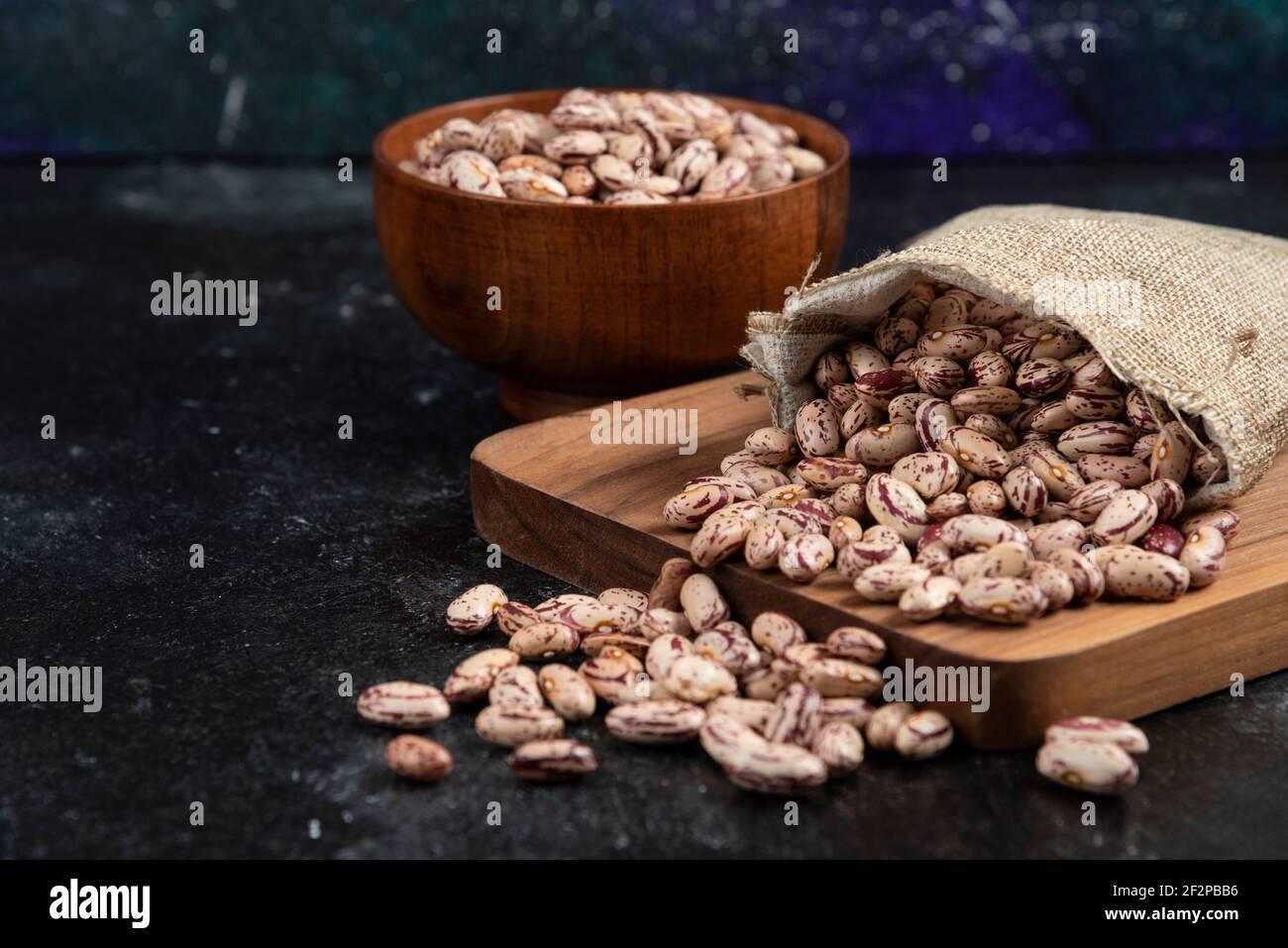 Sackcloth of dried raw beans placed on dark background Stock Photo