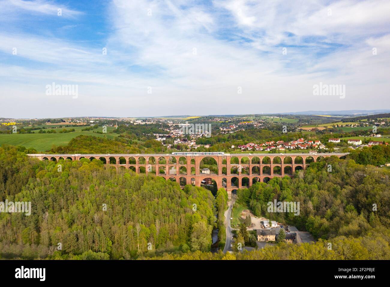 Largest brick arch bridge in the world (574 m long, 78 m high) Train, houses, valley, forest Stock Photo