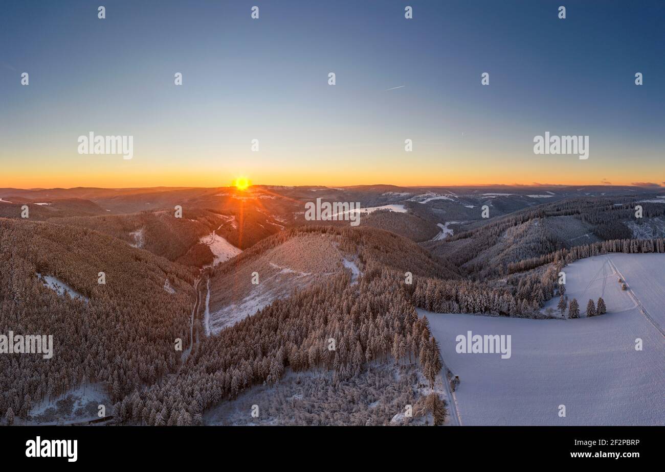 Germany, Thuringia, Grossbreitenbach, Allersdorf, valleys, forest, mountains, road, snow, sunrise, back light, aerial view Stock Photo