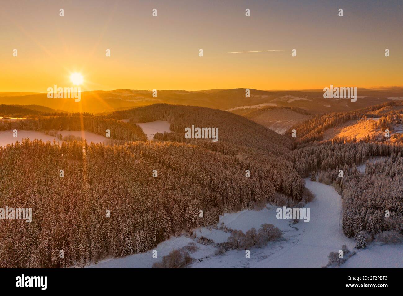Germany, Thuringia, Grossbreitenbach, Allersdorf, forest, valley, mountains, brook, snow, sunrise, back light, aerial view Stock Photo
