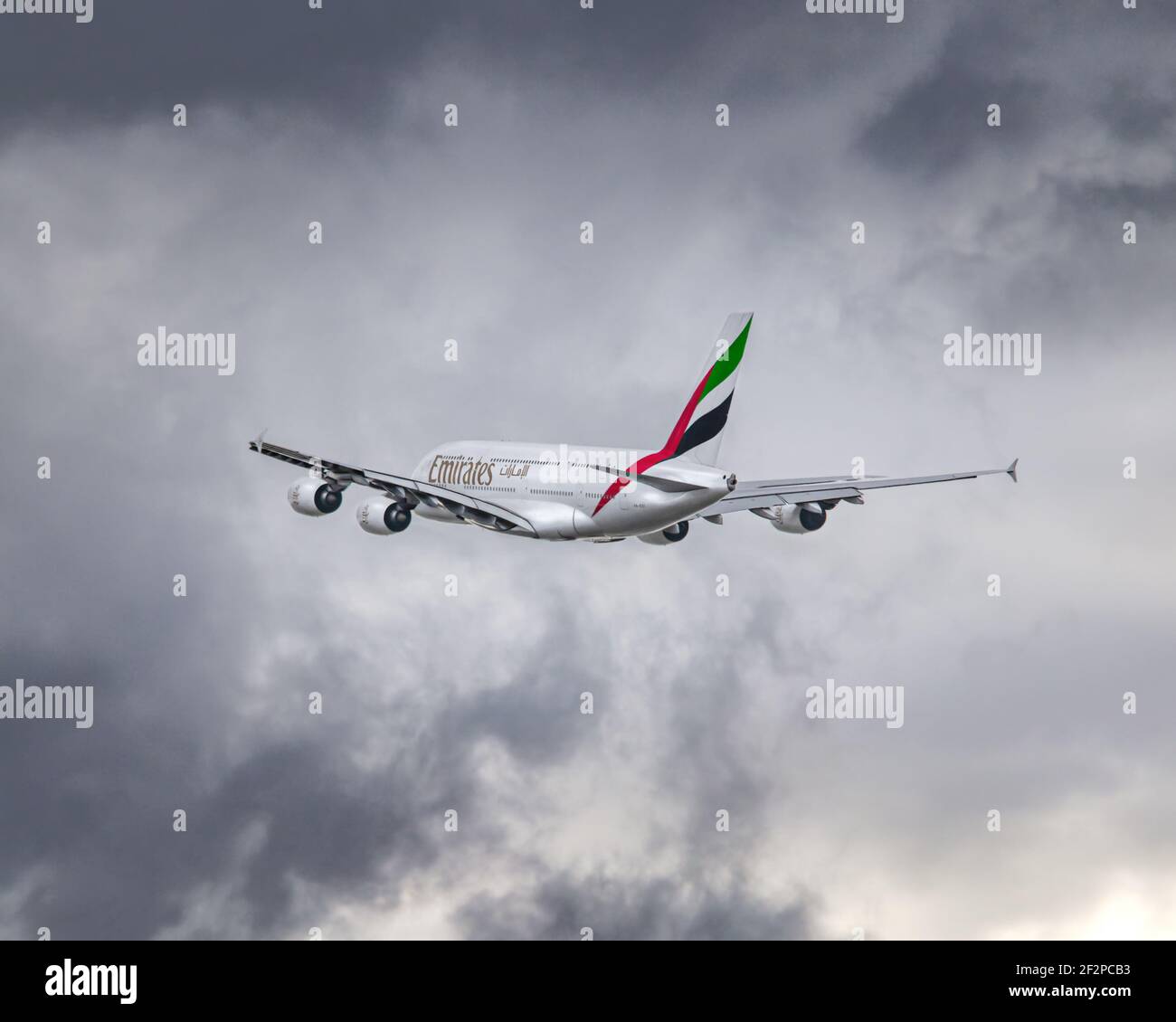 London, Heathrow Airport - August 18, 2019: Dramatic shot of an Emirates A380 flying towards bad weather with dark thunderous rain clouds. image Abdul Stock Photo