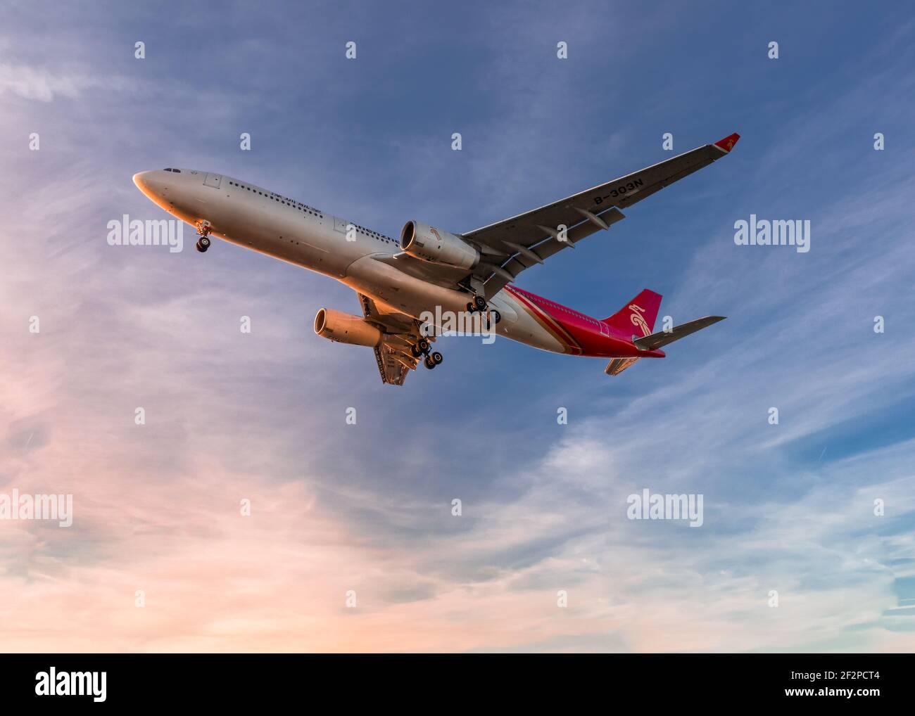 London, Heathrow Airport - May 2019, Chinese Airline, Shenzhen Airlines Airbus A330 Aircraft, flying low overhead as it comes in to land at sunset. im Stock Photo