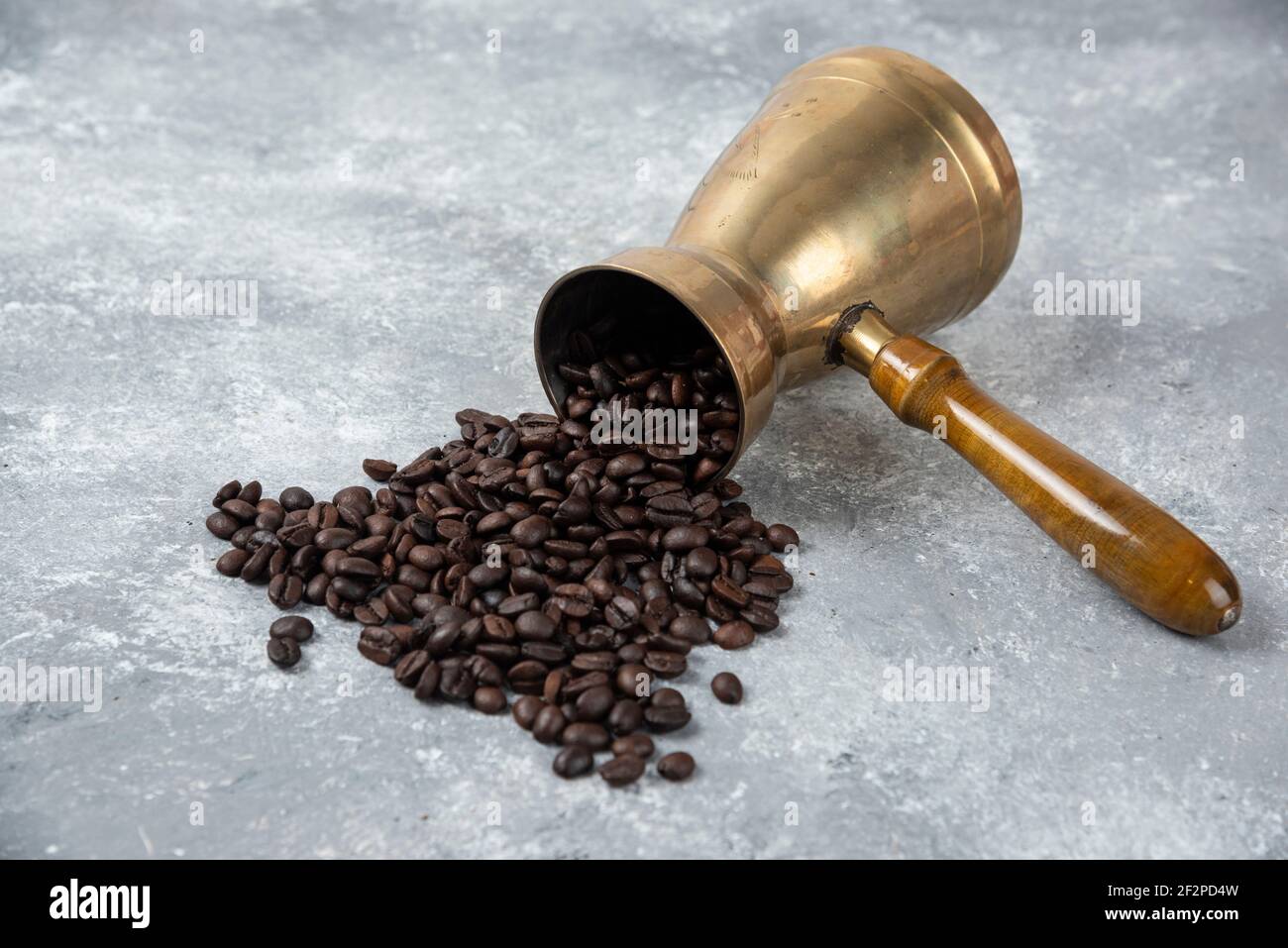 Coffee maker full of roasted coffee beans on marble surface Stock Photo
