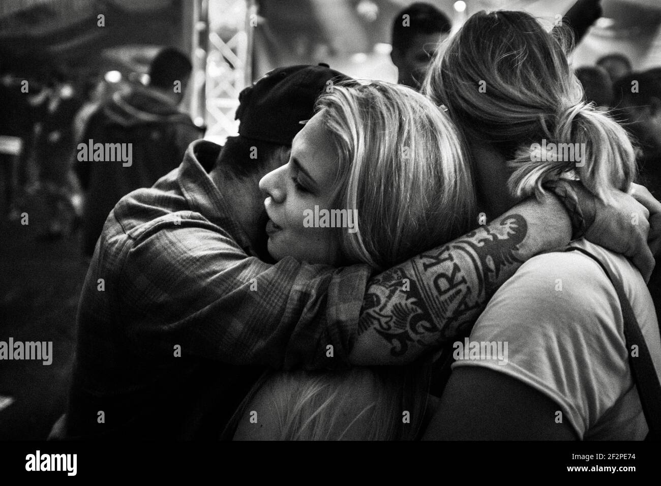 Germany, Bavaria, Antdorf, festival week of the traditional costume association. Man hugs two women during party in marquee. Stock Photo