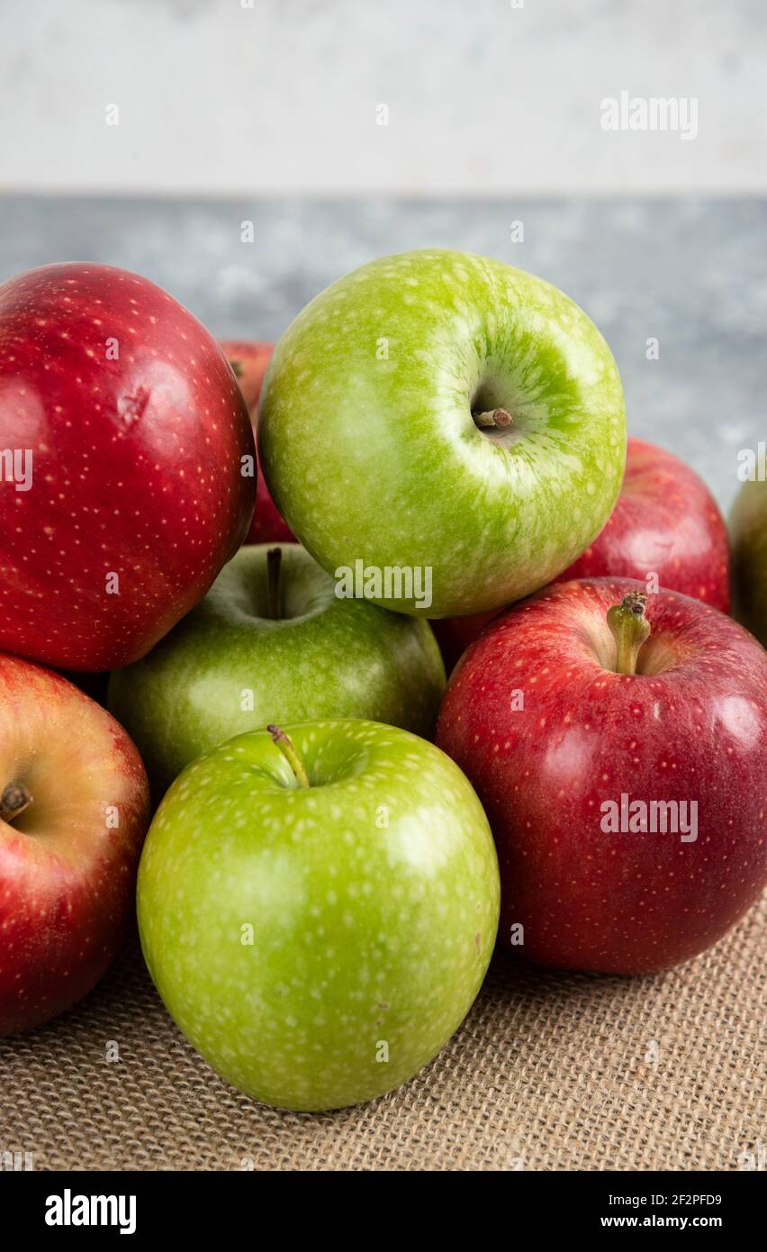 Bunch of fresh green and red apples placed on burlap Stock Photo