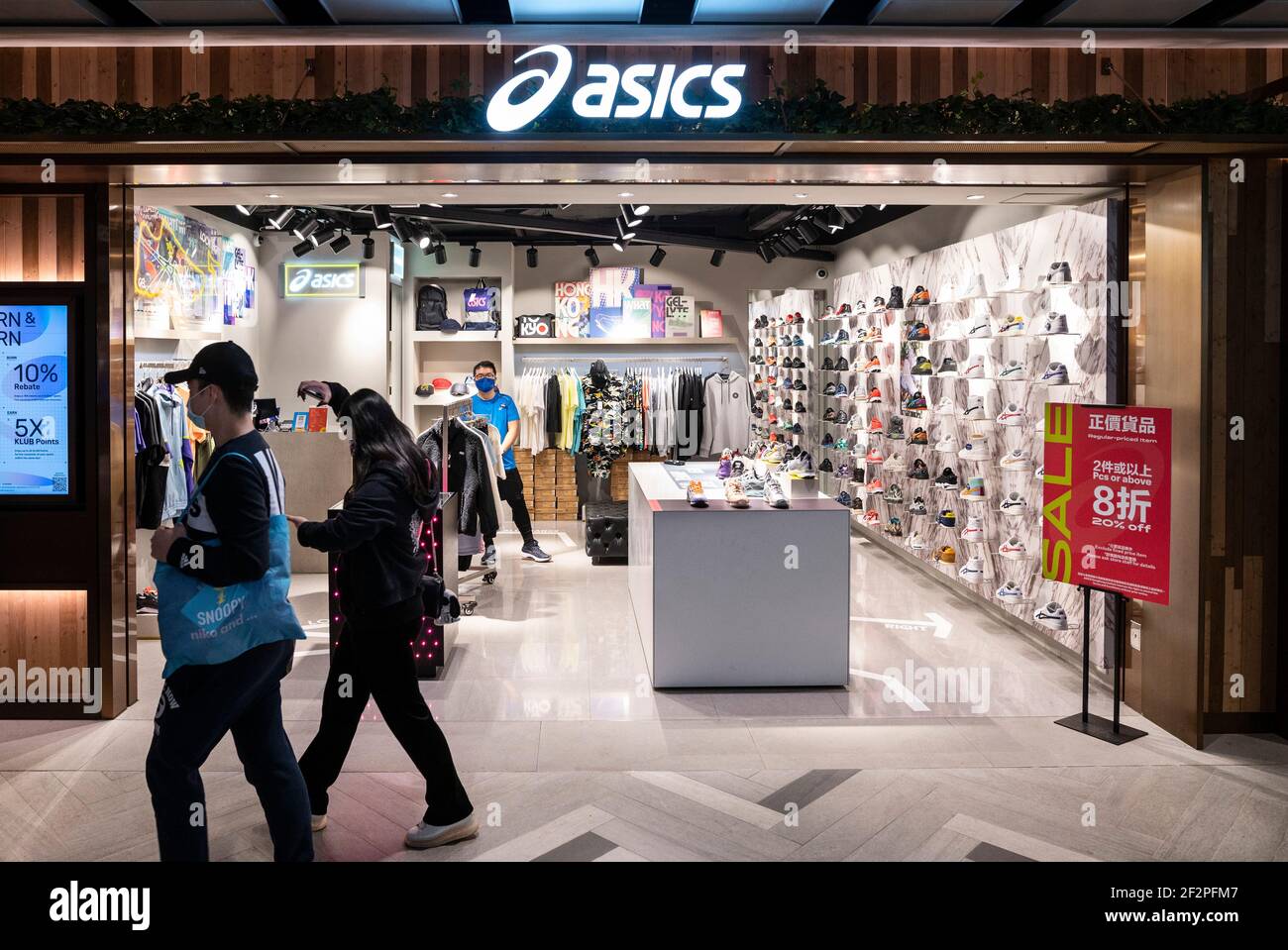 Hong Kong, China. 12th Mar, 2021. Shoppers walk past the Japanese  multinational sports equipment brand Asics store seen in Hong Kong. (Photo  by Chukrut Budrul/SOPA Images/Sipa USA) Credit: Sipa USA/Alamy Live News
