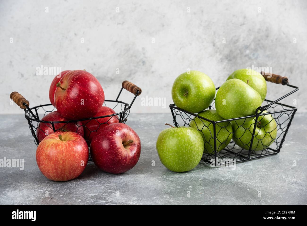 Pile of fresh green and red apples placed in metal baskets Stock Photo