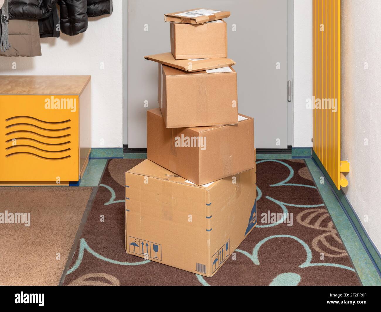 corona pandemic-related flood of goods delivery parcel stacks in the house entrance Stock Photo