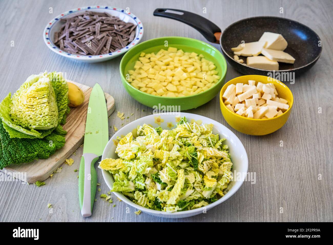 diced potatoes, cabbage, cheese, melted butter and garlic: ingredients for the preparation of Pizzoccheri, a typical dish from Valtellina (Italy) and the canton of Graubünden (Switzerland) Stock Photo