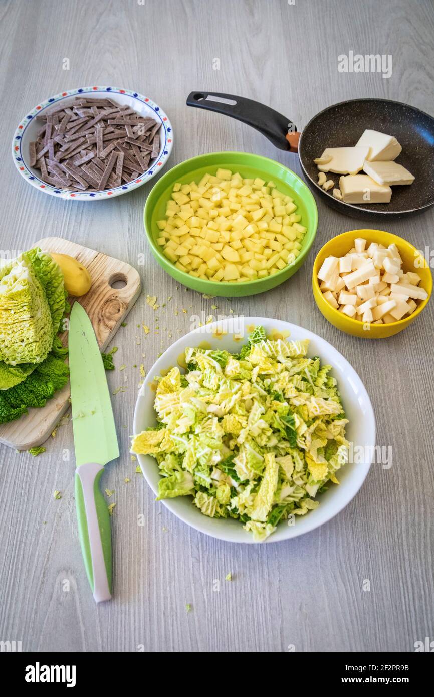 diced potatoes, cabbage, cheese, melted butter and garlic: ingredients for the preparation of Pizzoccheri, a typical dish from Valtellina (Italy) and the canton of Graubünden (Switzerland) Stock Photo