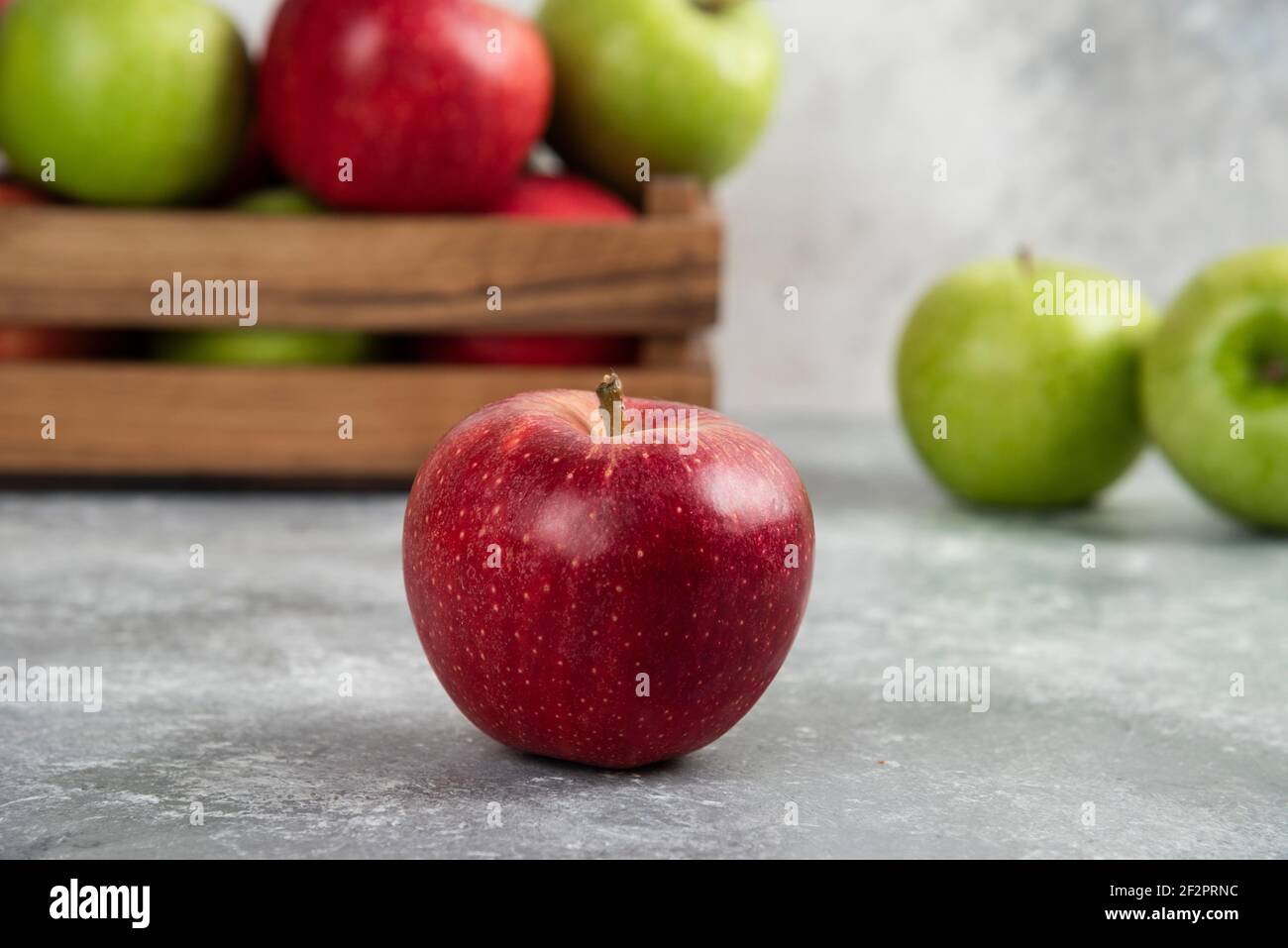 Whole wet green and red apples on wooden cutting board Stock Photo