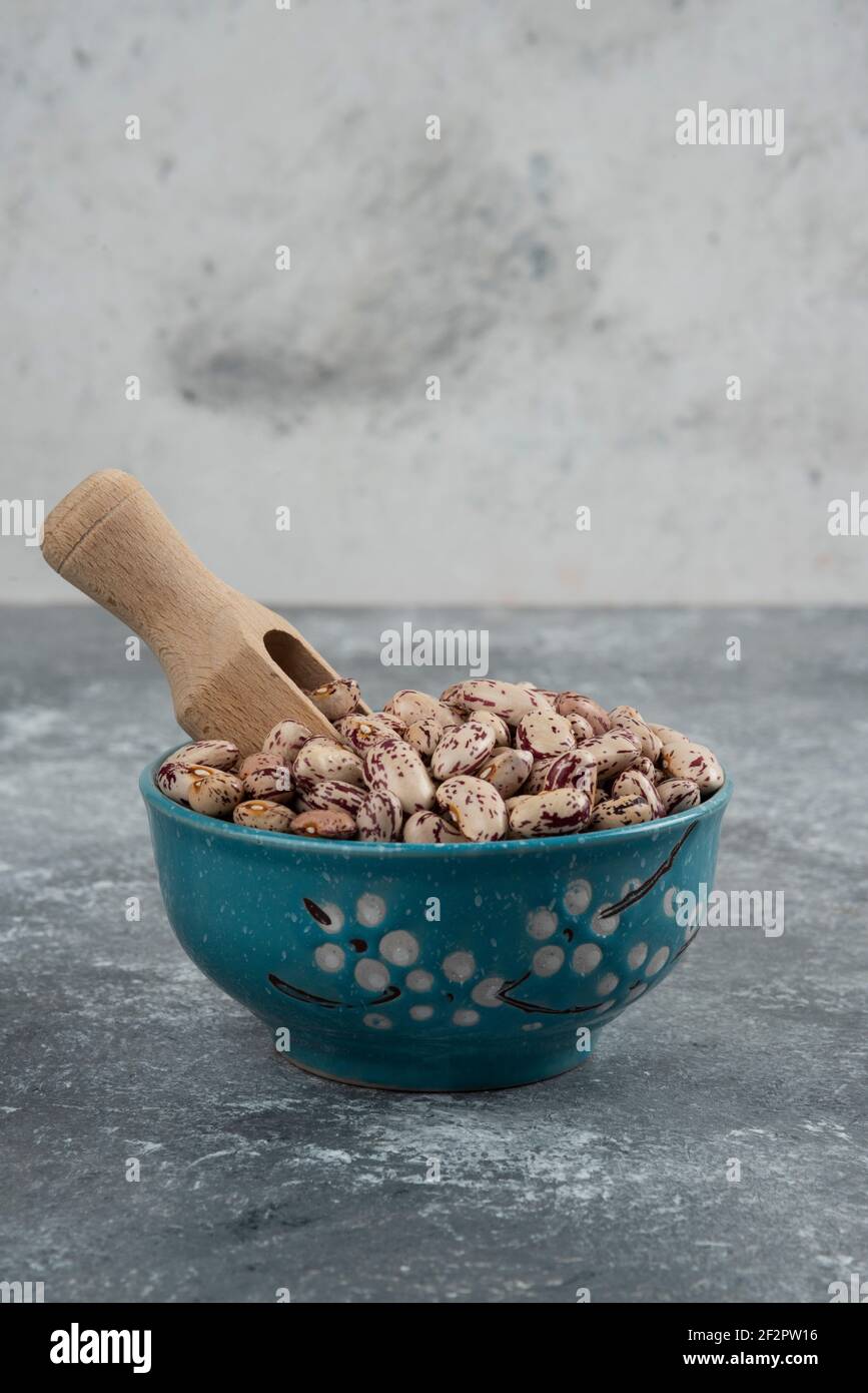 Raw bean grains displayed in bowls on marble surface Stock Photo
