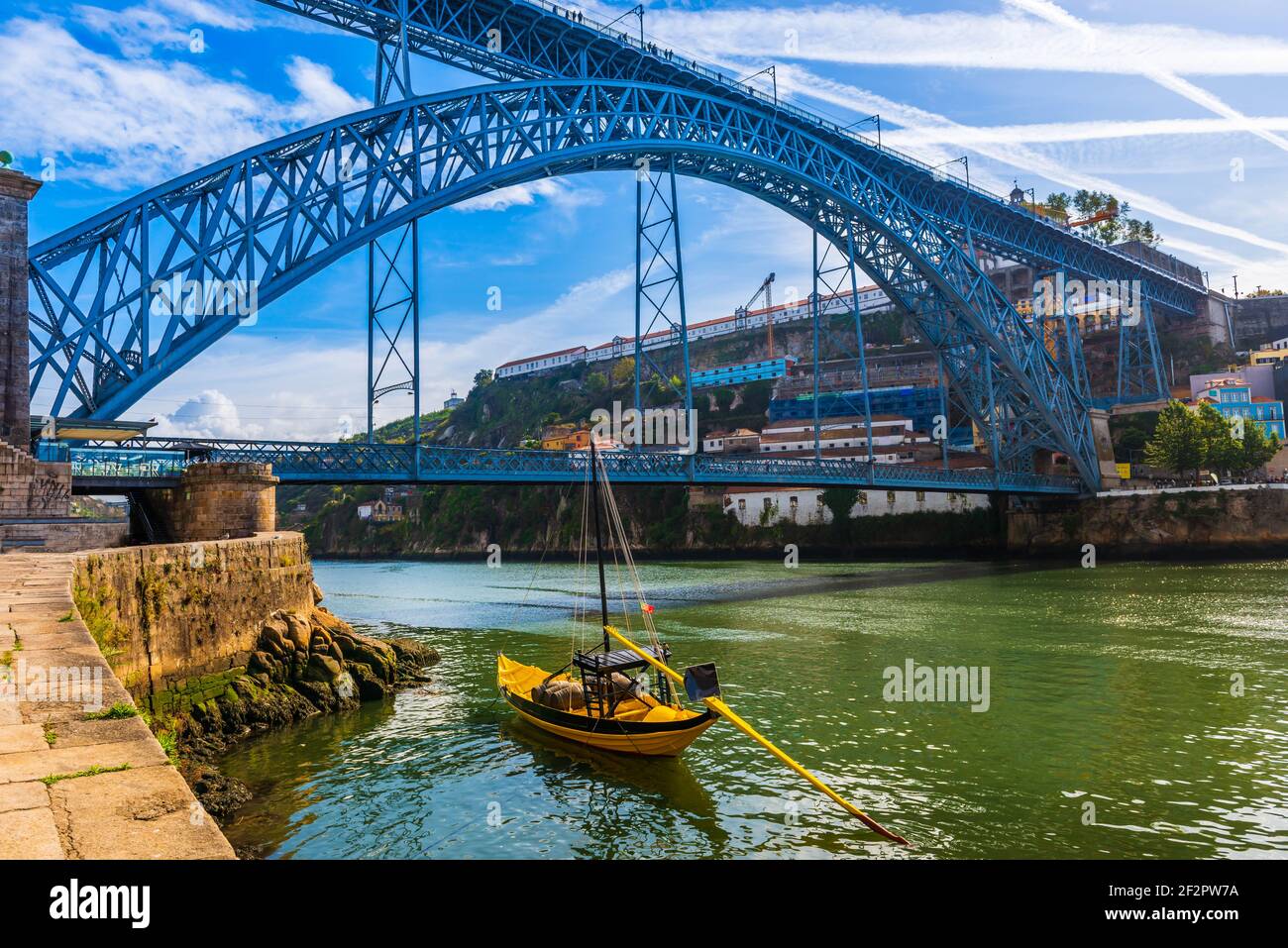 Boat in front of the Dom Luis I bridge on the Douro River in Porto, Portugal Stock Photo