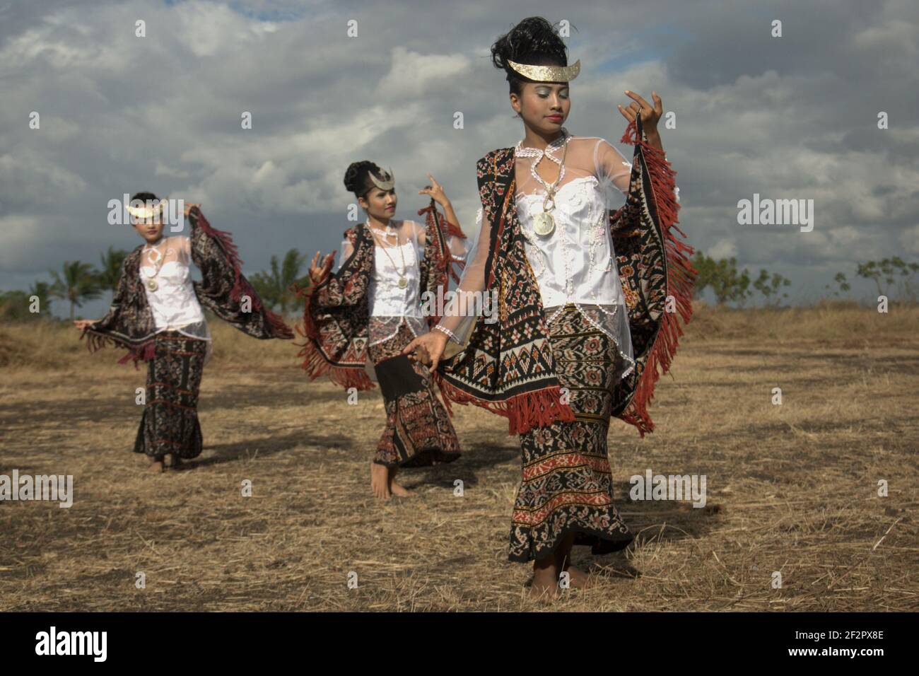 Young women dancing in a rehearsal before a ceremonial event attended by Indonesian officials, which is to release Rote Island's endemic snake-necked turtle (Chelodina mccordi) to one of the suitable habitats in Lake Peto, Maubesi village, Rote Island, Indonesia. Stock Photo