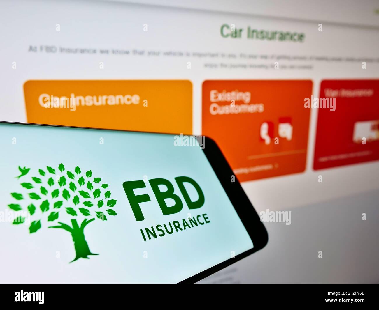 Smartphone with business logo of Irish insurance company FBD Insurance plc on screen in front of web page. Focus on center of phone display. Stock Photo