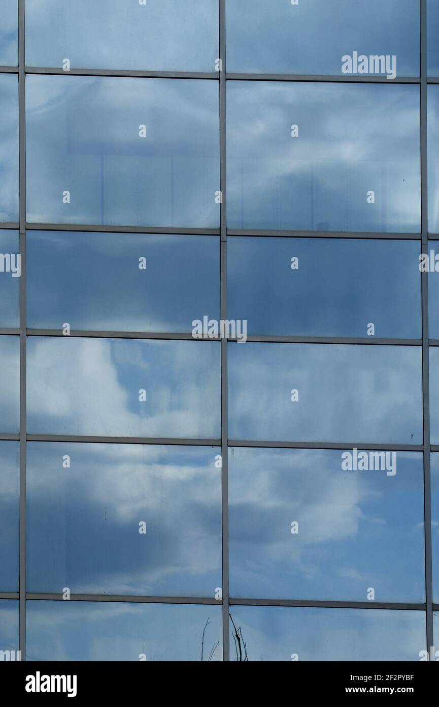 Reflection of a cloudy sky in glass wall of an office building Stock ...