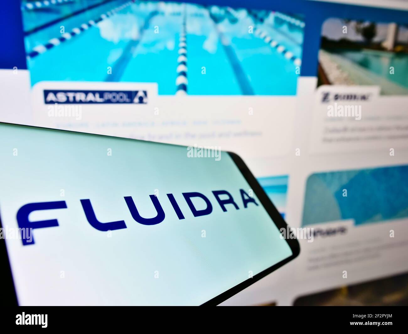 Mobile phone with business logo of Spanish wellness equipment company Fluidra S.A. on screen in front of webpage. Focus on center of phone display. Stock Photo