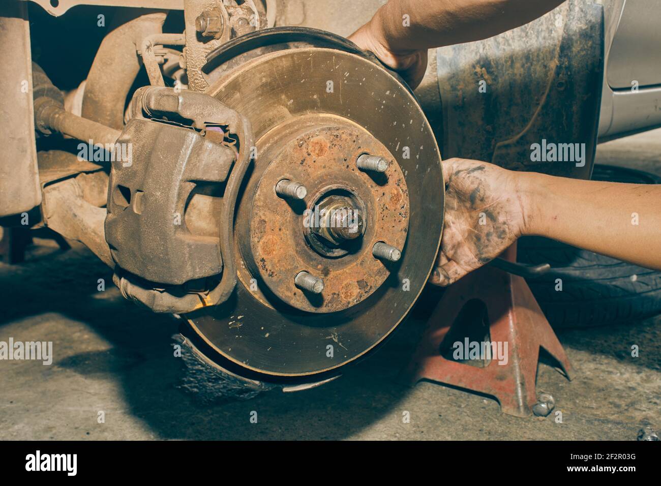 Car Mechanic Repair and Maintenance Front Wheel Hub in Car Repair Shop in Vintage Tone Stock