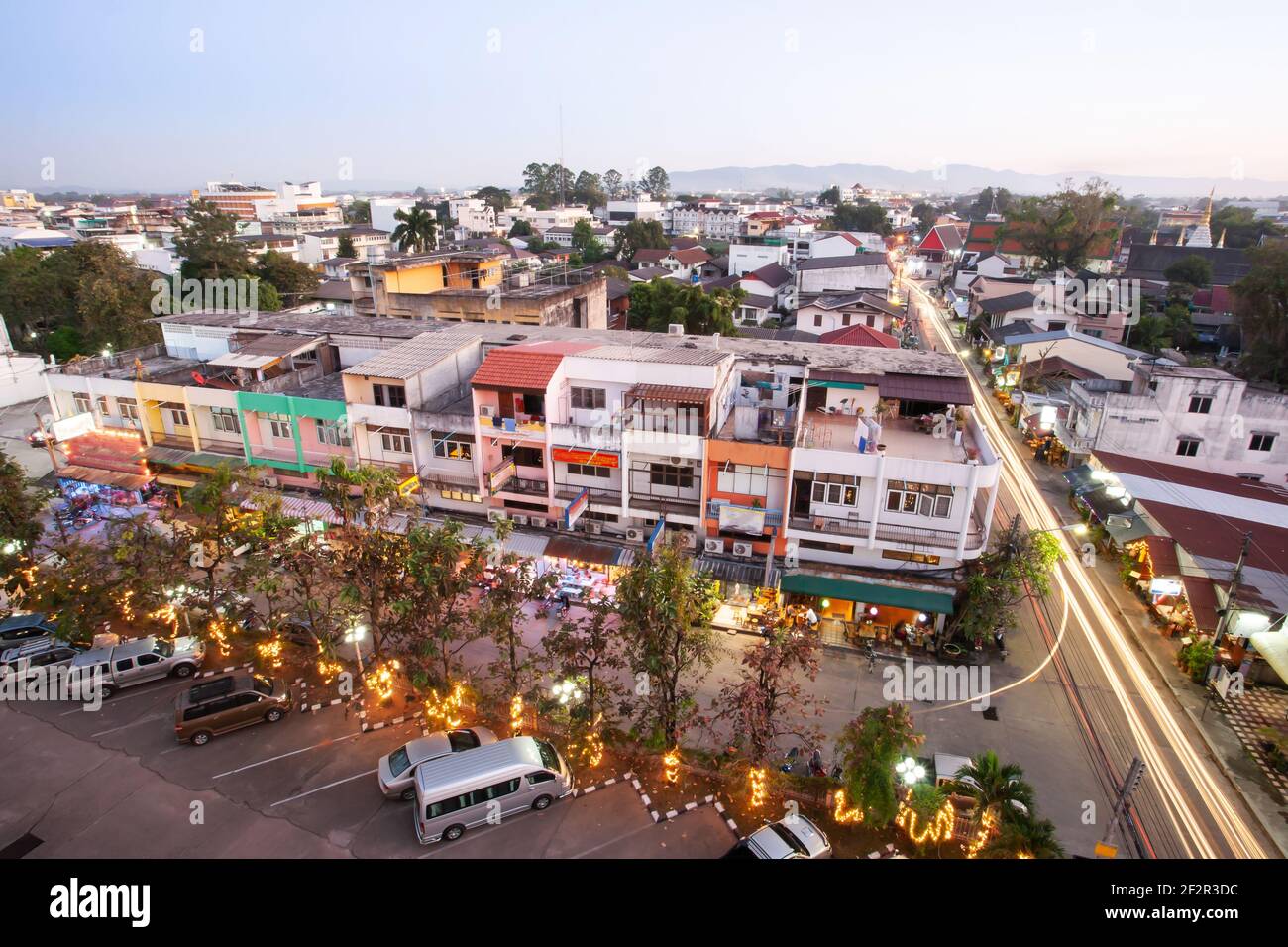 Aerial view of Chiang Rai City at dusk, bright and glowing neon lights and lights trails on the streets, tourist attractions in Thailand. Stock Photo