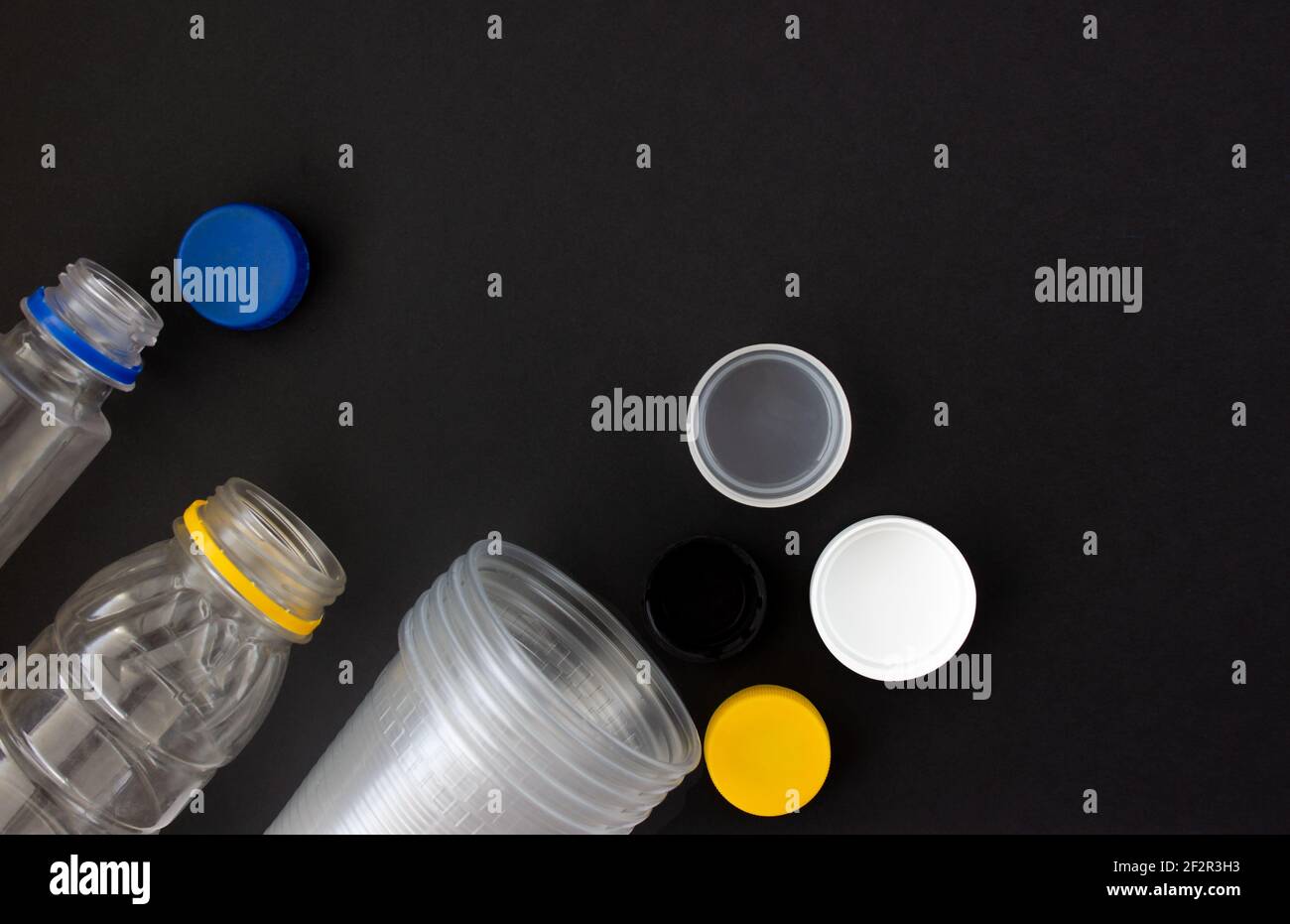 disposable plastic tableware on a black background. Environmental pollution. Space for text Stock Photo
