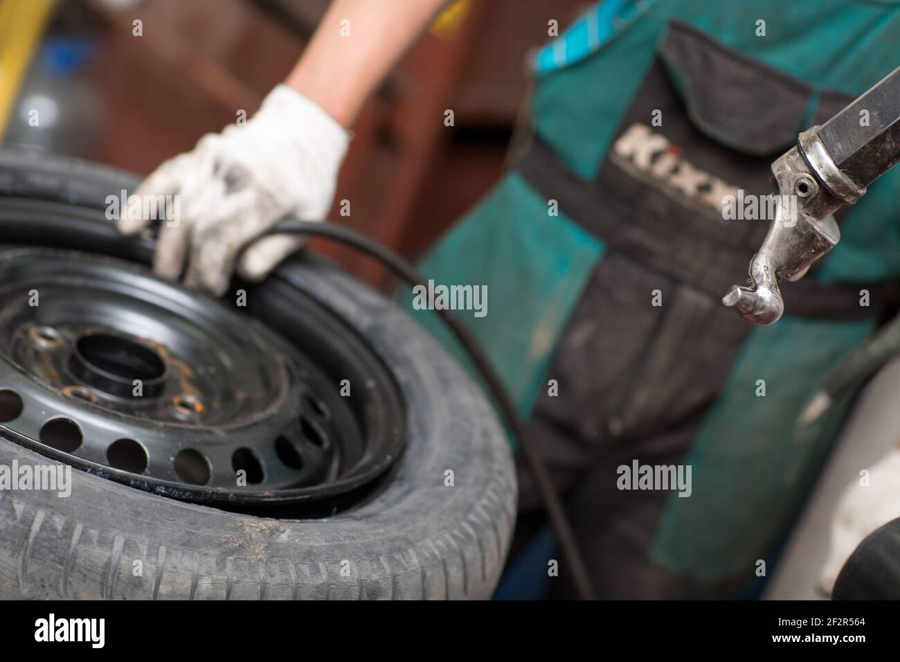 Mechanic changing car tire fitting. Wheel tyre repairing Stock Photo