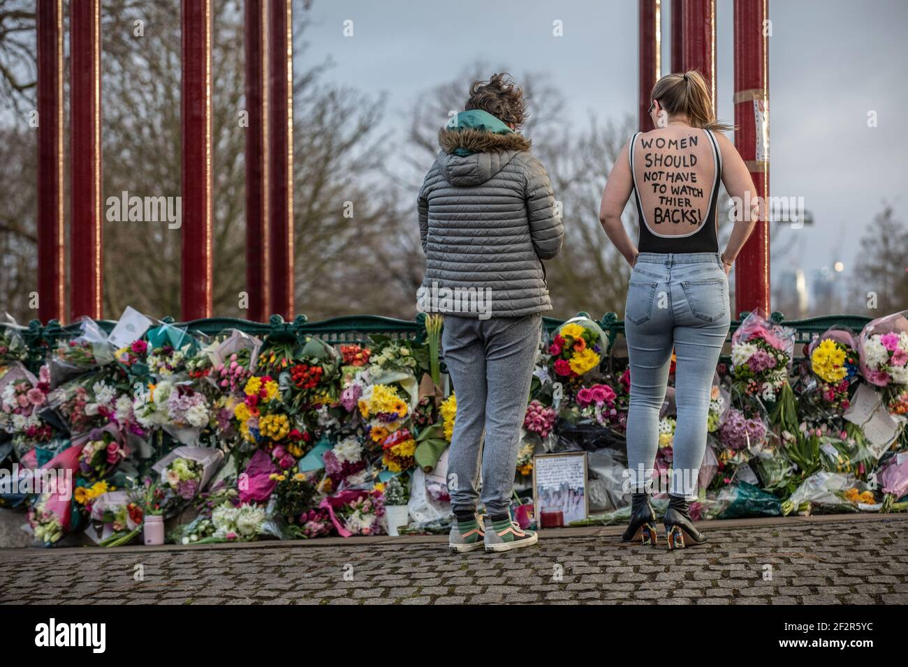London, UK. 13th Mar 2021. Women's Safety Campaigners stand looking at the flowers and tributes for Miss Everard at the bandstand on Clapham Common where they are planning to stage a vigil tonight. 13th March 2021 Clapham Common, Southwest London, England, United Kingdom Credit: Jeff Gilbert/Alamy Live News Stock Photo