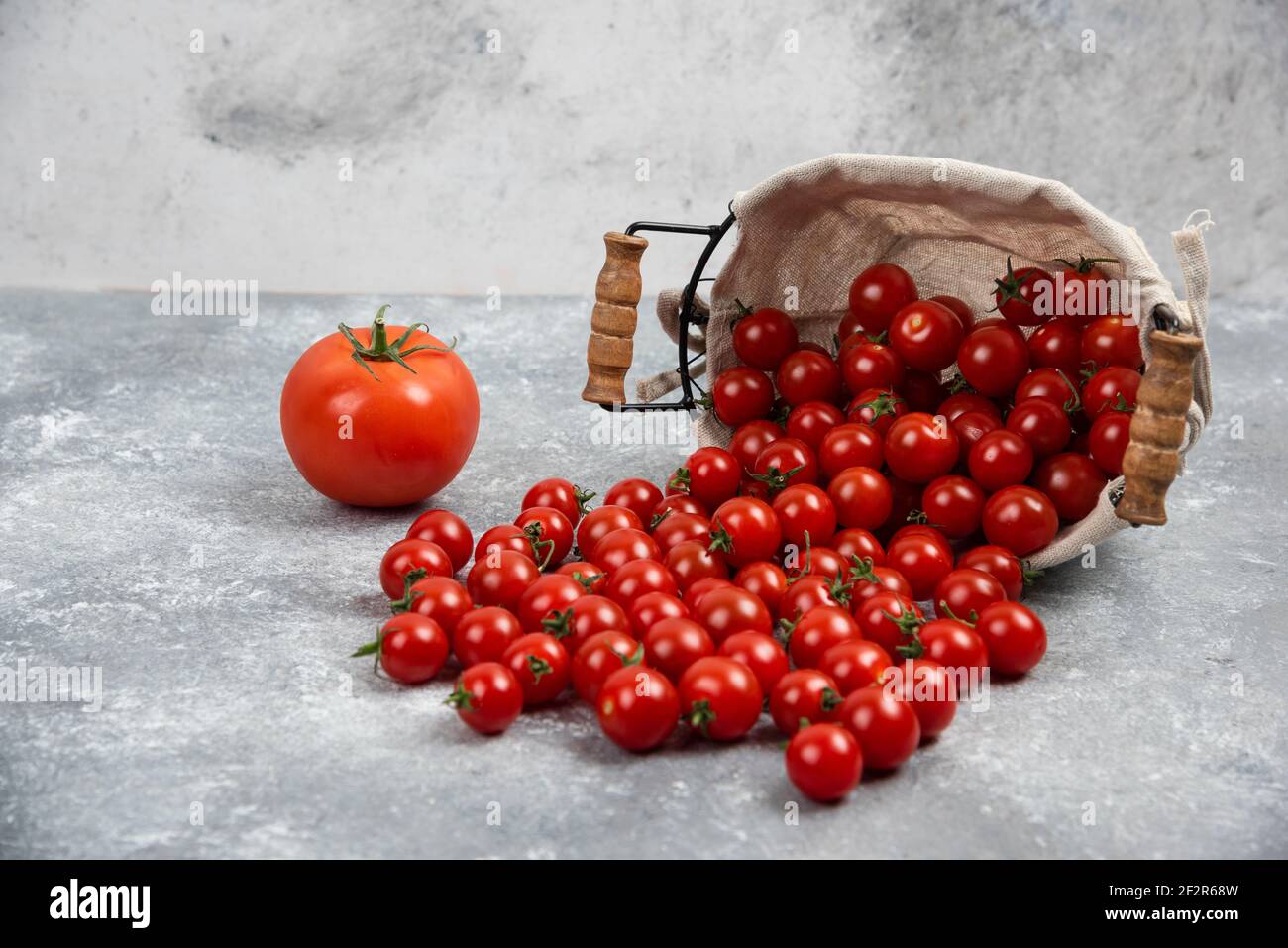 Red cherry tomatoes on marble grey background Stock Photo - Alamy