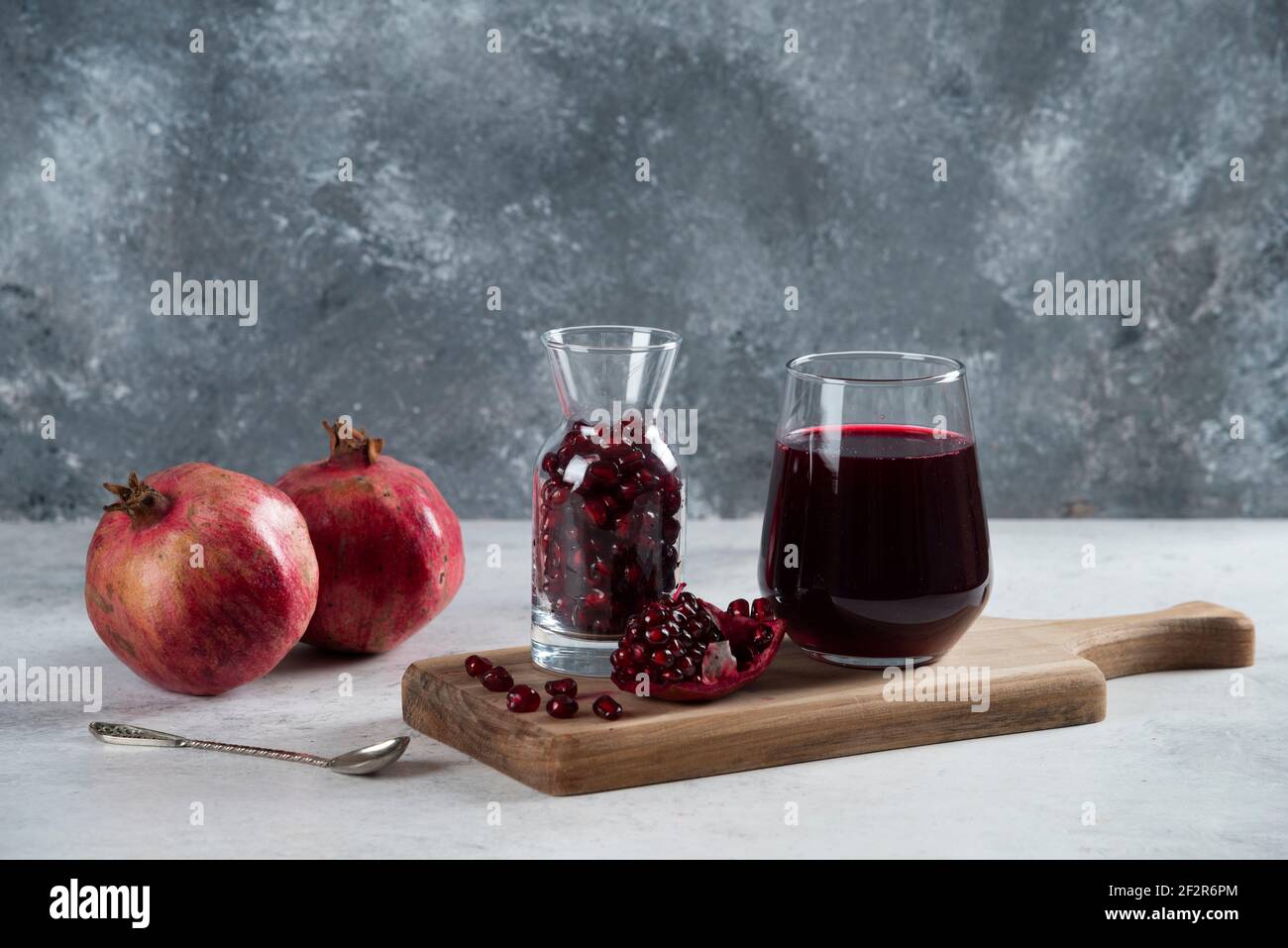 A small jar full of pomegranate and a cup of juice Stock Photo