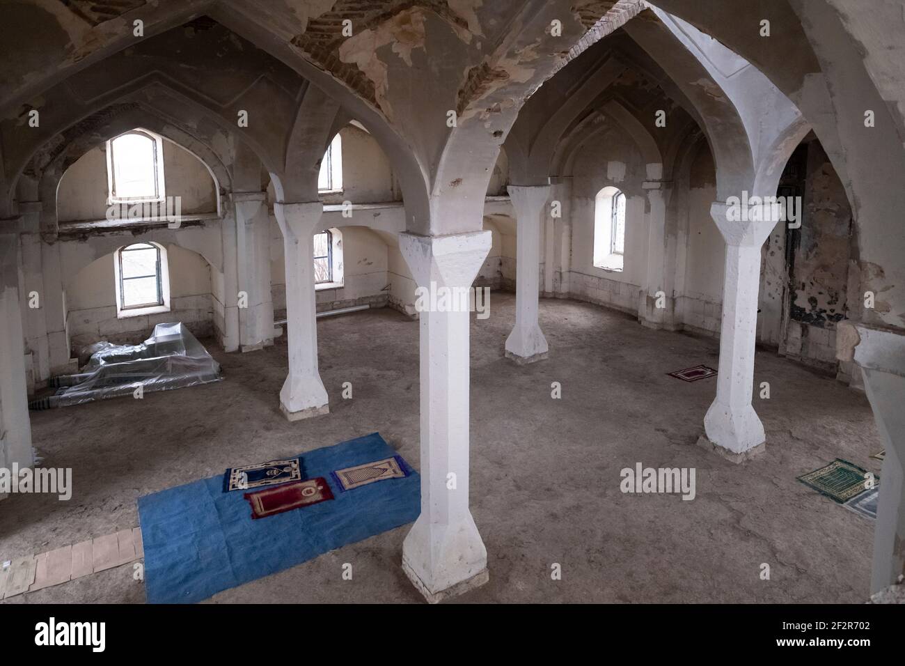 AGDAM, AZERBAIJAN - DECEMBER 14: Personal prayer mats spread inside the neglected and partially destroyed 19th century Juma Mosque the only building left standing in the town of Agdam which was destroyed by Armenian forces during the First Nagorno-Karabakh War on December 14, 2020 in Agdam, Azerbaijan. The town and its surrounding district were returned to Azerbaijani control as part of an agreement that ended the 2020 Nagorno-Karabakh War. Stock Photo