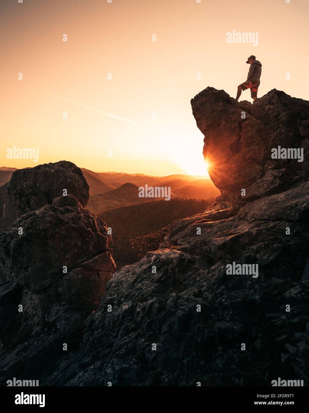 Man on top of mountain enjoying view during sunset Stock Photo - Alamy