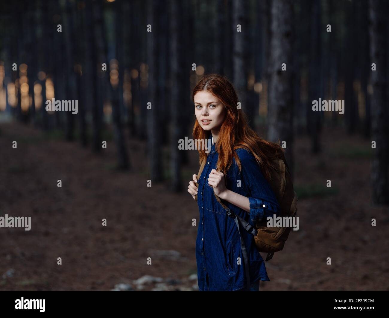 Woman Tourist with a backpack on her back walks on nature in the forest ...