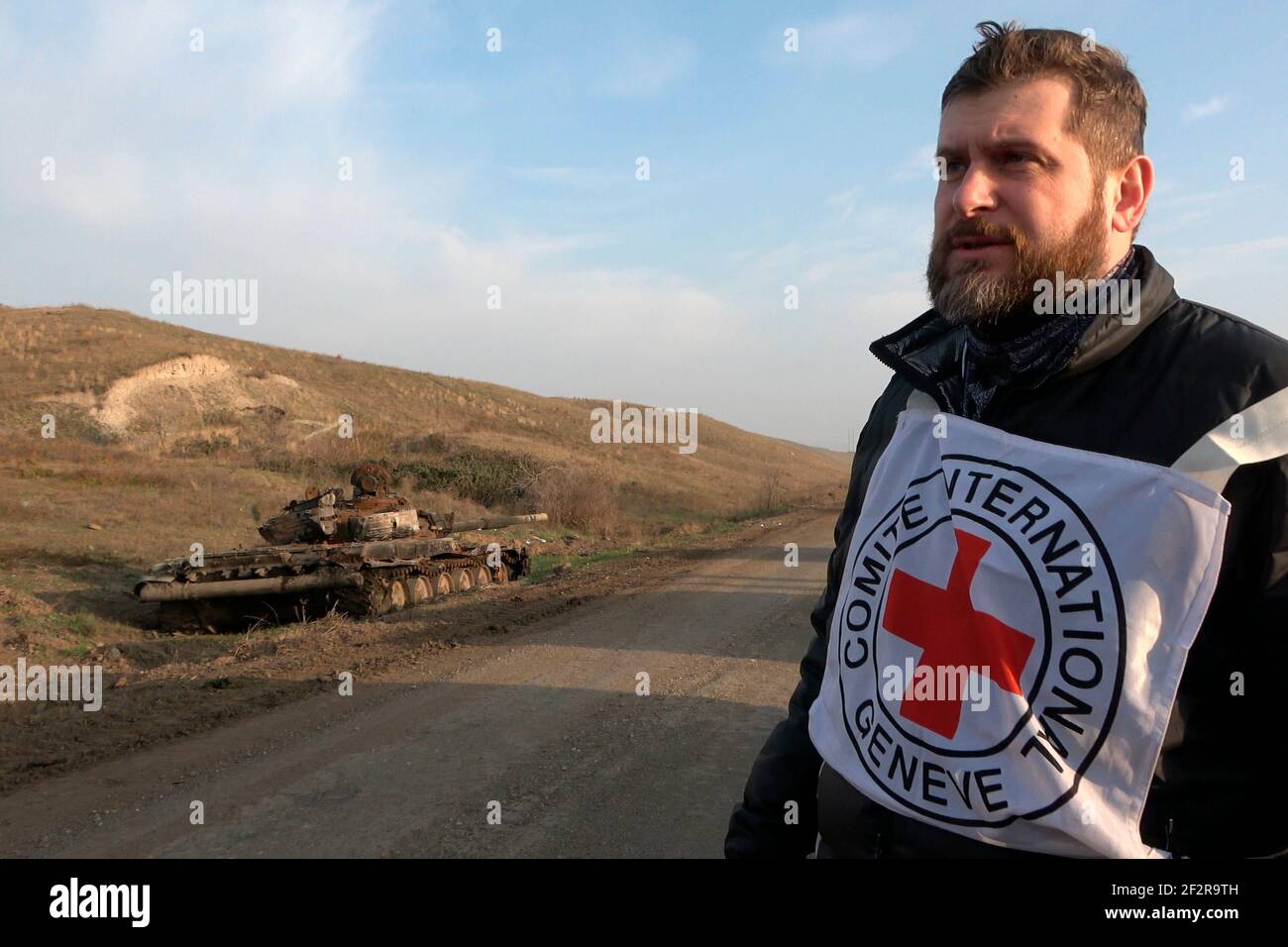 JABRAYIL, AZERBAIJAN - DECEMBER 15: A member of the International Committee of the Red Cross stands next to a destroyed Armenian T-72 tank after looking for remains of Armenian fighters killed in the conflict over the disputed region of Nagorno-Karabakh on December 15 2020 in the Jabrayil Rayon of Azerbaijan. Heavy clashes erupted over Nagorno-Karabakh in late September during which more than 5,600 people, including civilians, were killed. The sides agreed to a Russia-brokered cease-fire deal that took effect on November 10 Stock Photo