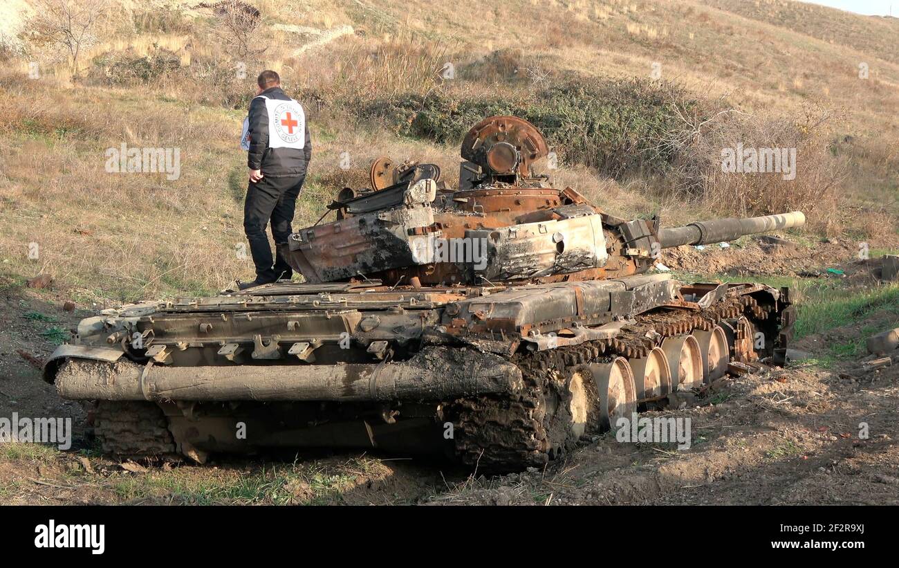 JABRAYIL, AZERBAIJAN - DECEMBER 15: A member of the International Committee of the Red Cross examines a destroyed Armenian T-72 tank for remains of Armenian fighters killed in the conflict over the disputed region of Nagorno-Karabakh on December 15 2020 in the Jabrayil Rayon of Azerbaijan. Heavy clashes erupted over Nagorno-Karabakh in late September during which more than 5,600 people, including civilians, were killed. The sides agreed to a Russia-brokered cease-fire deal that took effect on November 10 Stock Photo